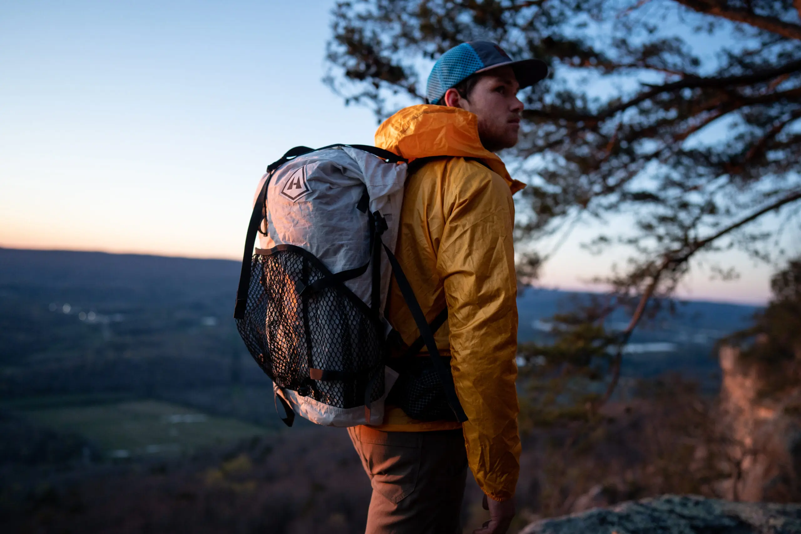 Man backpacking while wearing a yellow windbreaker jacket