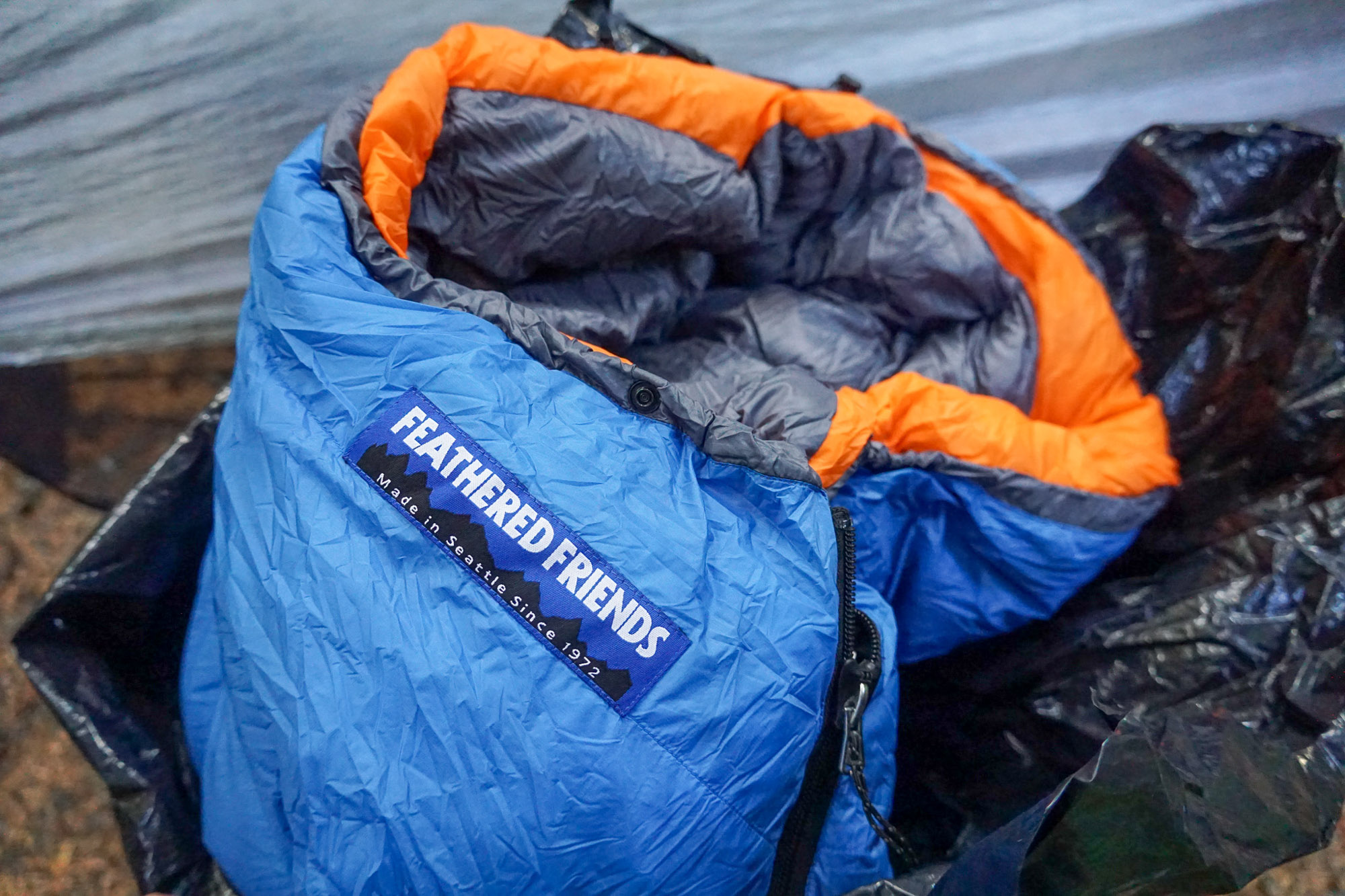 the blue swallow ul sleeping bag emerging from being stuffed into a backpacking pack