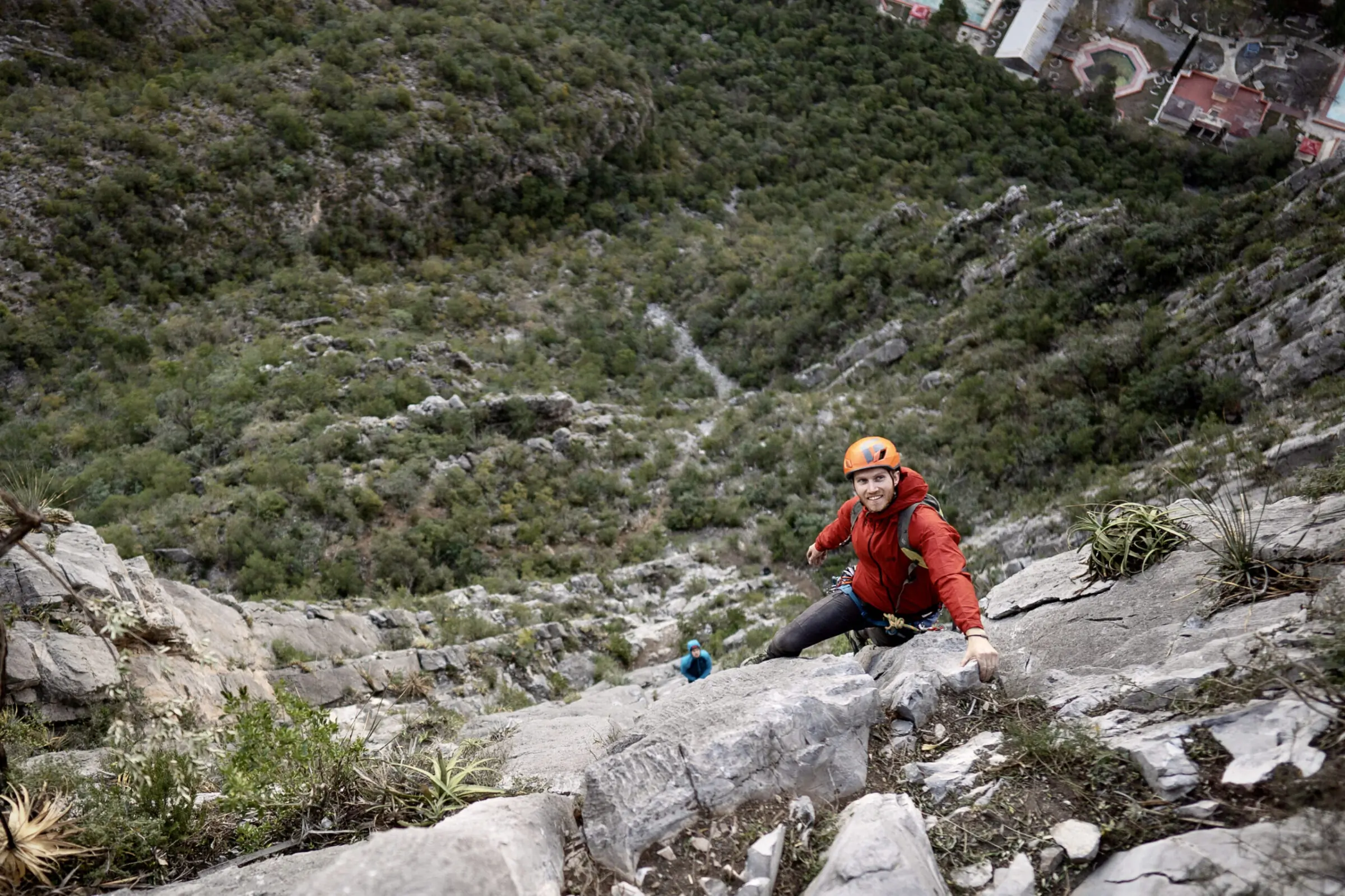Man rock climbing while wearing the Mountain Hardwear Kor Airshell