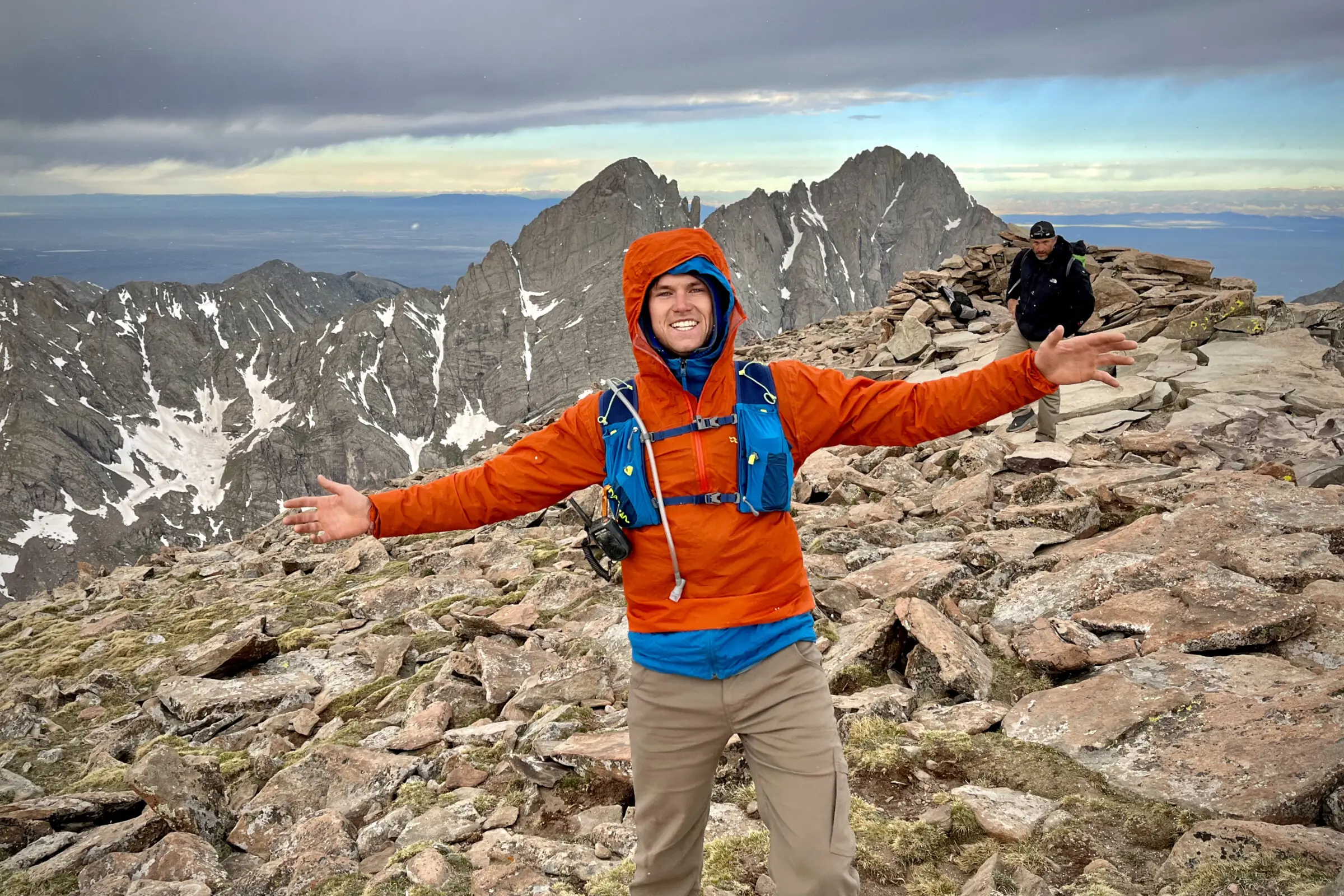 Man stand on top of a mountain in Colorado wearing a windbreaker jacket