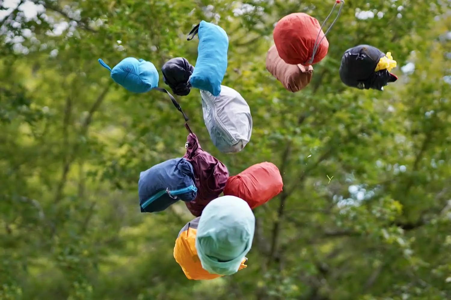 Windbreaker jackets in their stuff sacks are tossed into the air.