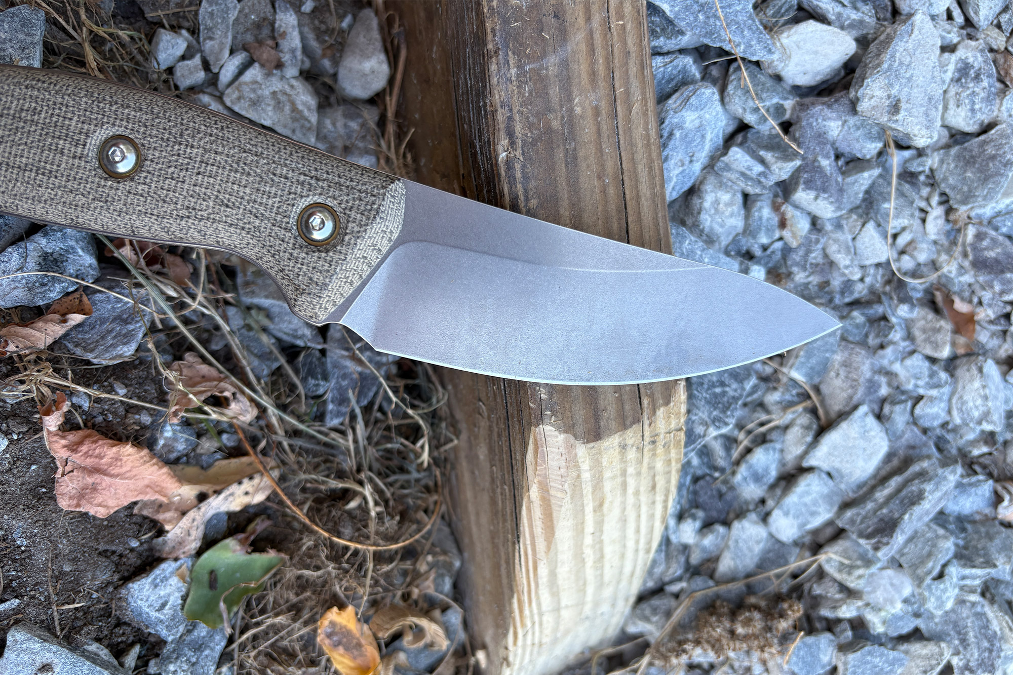 TJ Schwarz Confidente blade and handle resting on wood and gravel