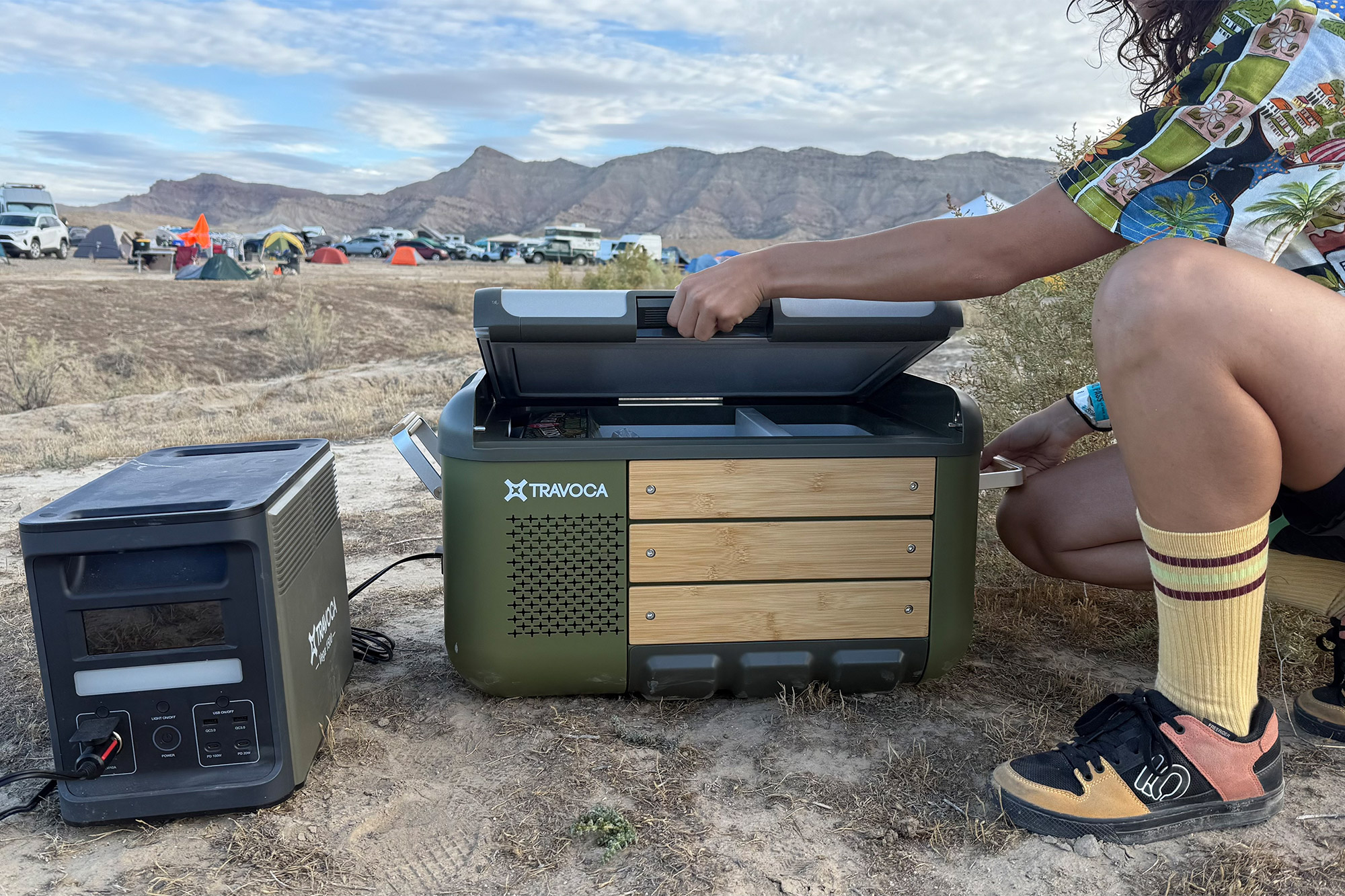 A camper opens the TRAVOCA Rigel DZ eCooler lid to access the cooled compartments