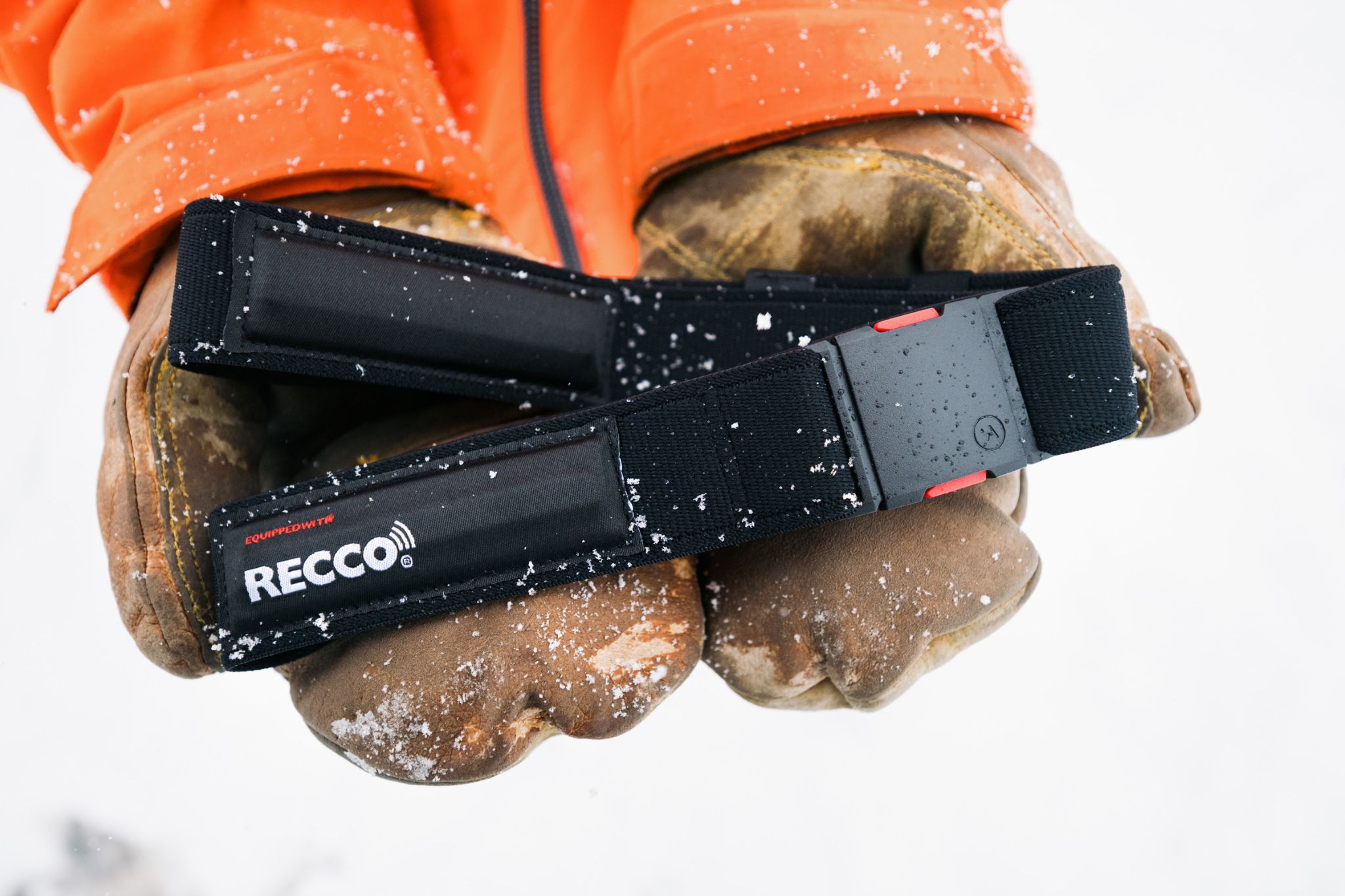 Close-up shot of person in snow wearing gloves holding belt