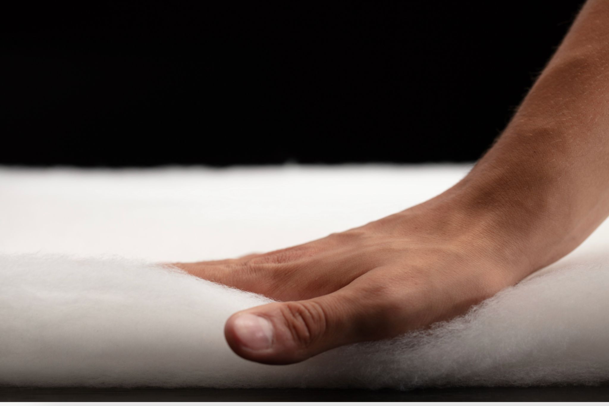 Hand presses down on insulation