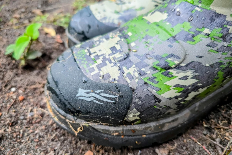 Close-up of the boot toe with water droplets on its camo surface