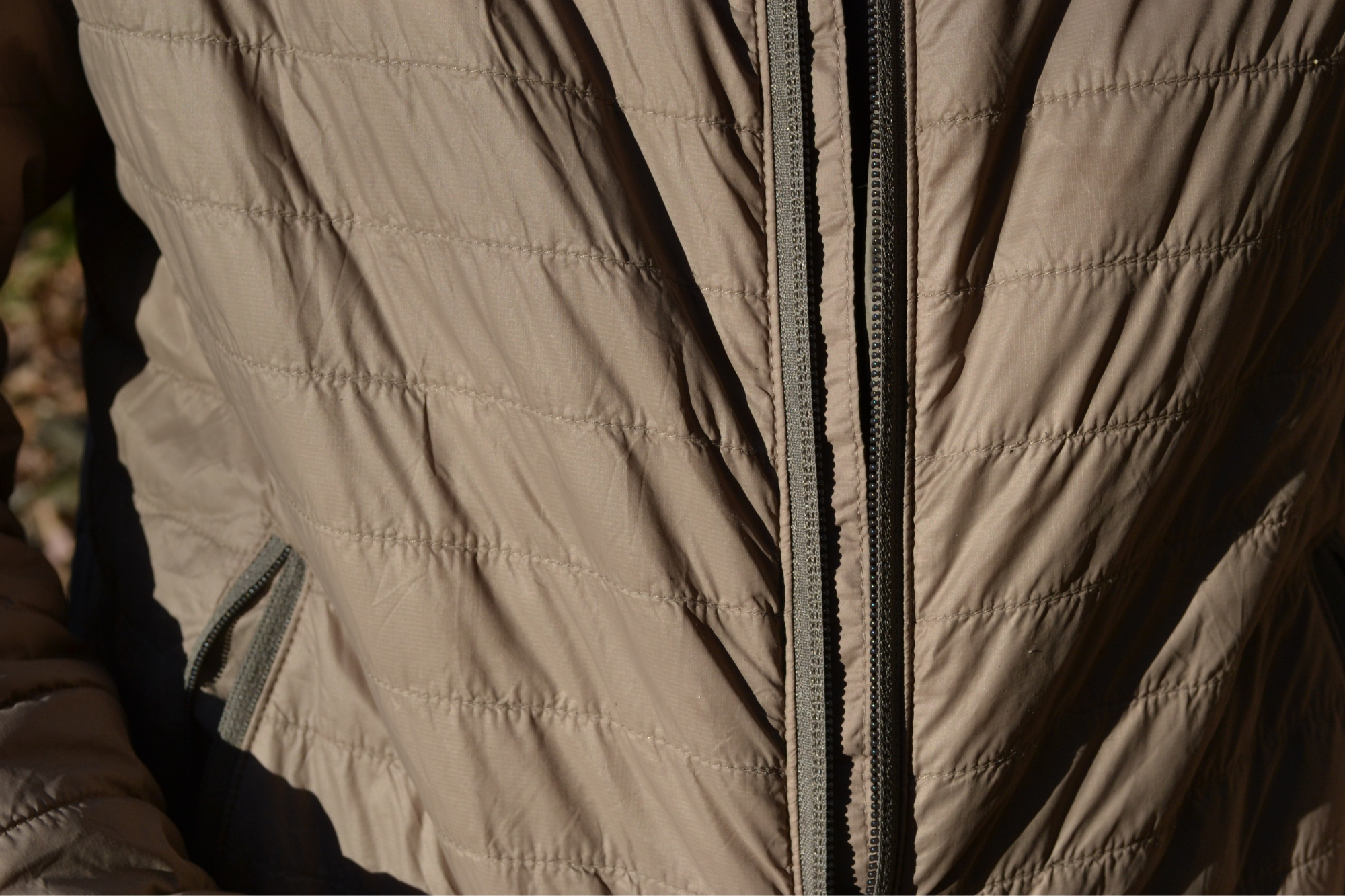 Close up shot of quilting on brown insulated jacket
