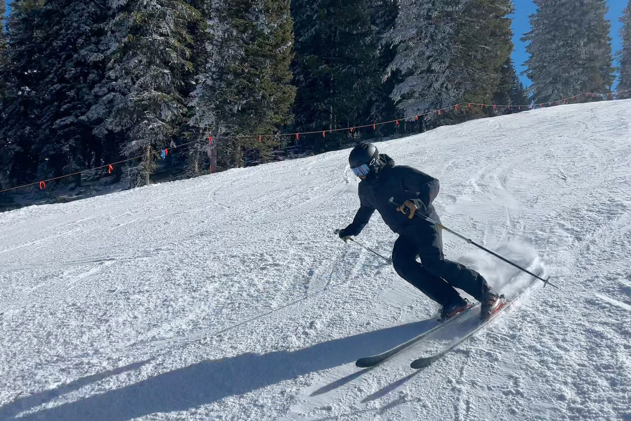 Skier carving on a groomed slope wearing Scarpa ski boots
