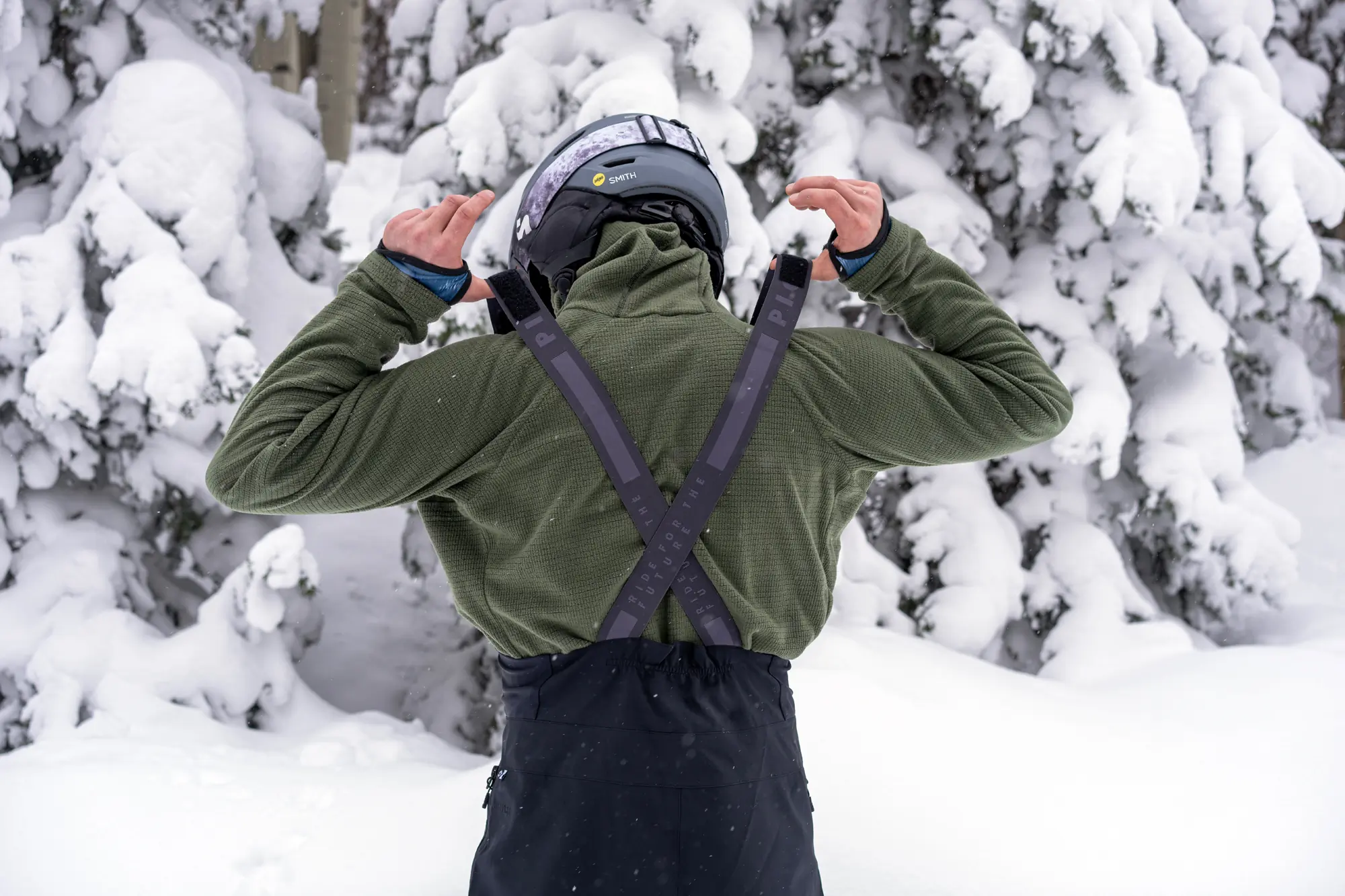 man pulling up suspenders on snow bibs 