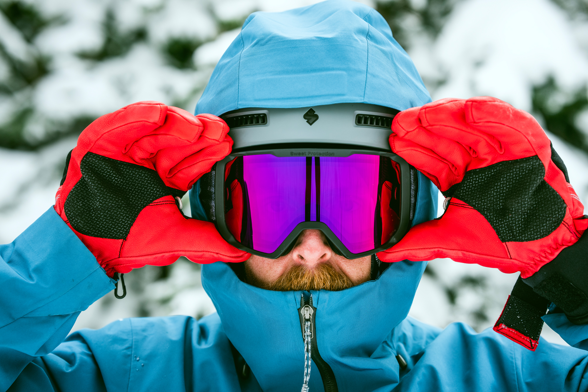 man holding ski gloves on goggle frame while wearing them 