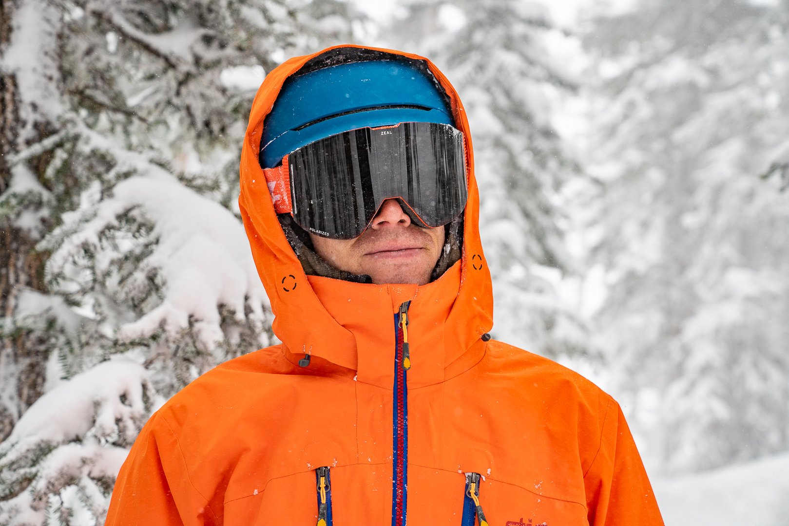 man testing bight orange ski jacket and goggles