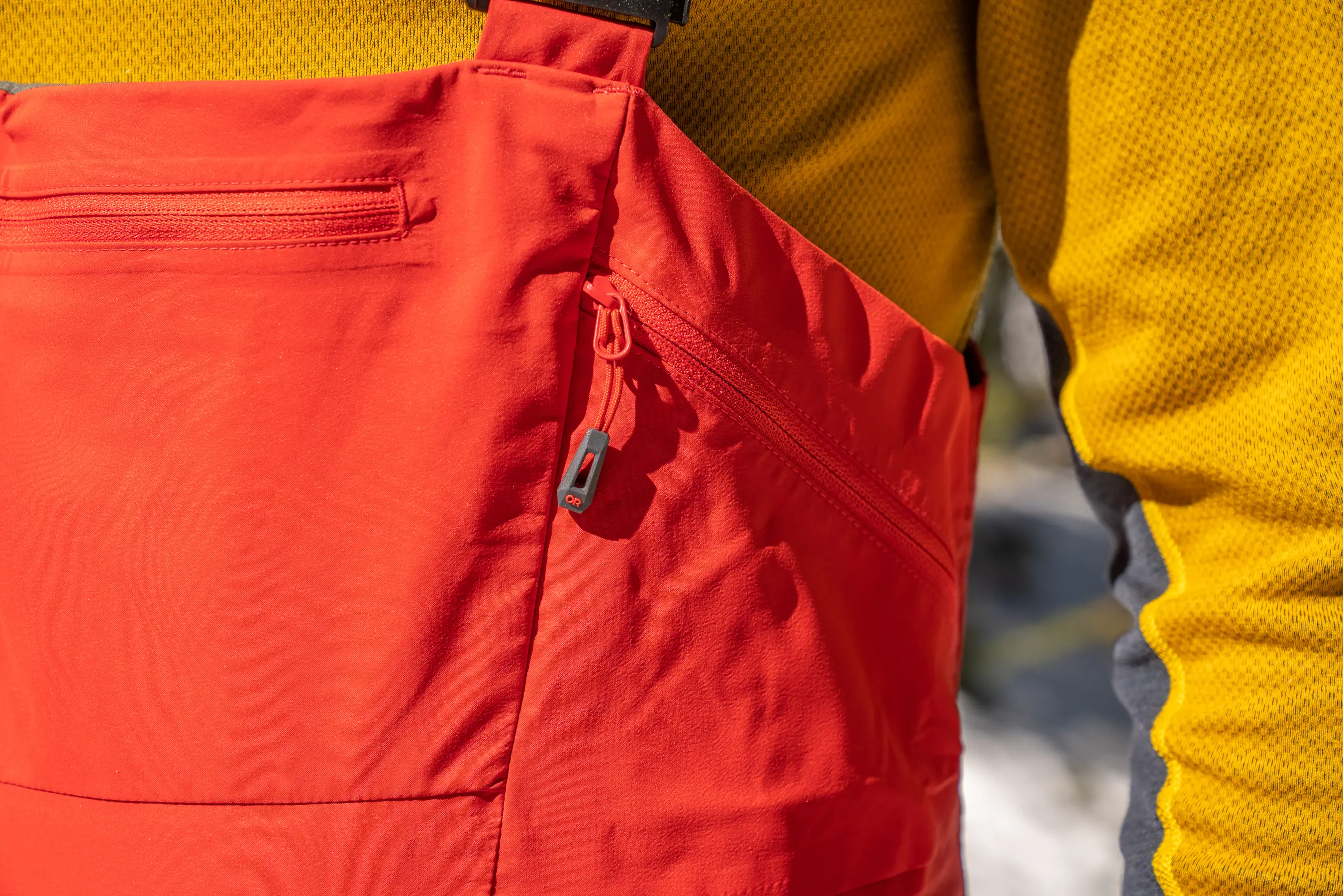 close-up photo of side pocket on upper torso of ski bibs 