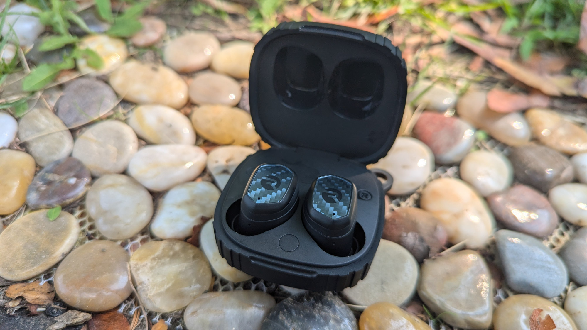 Gear Junkie - Best Wireless Earbuds - Raycon The Impact sitting on small rocks