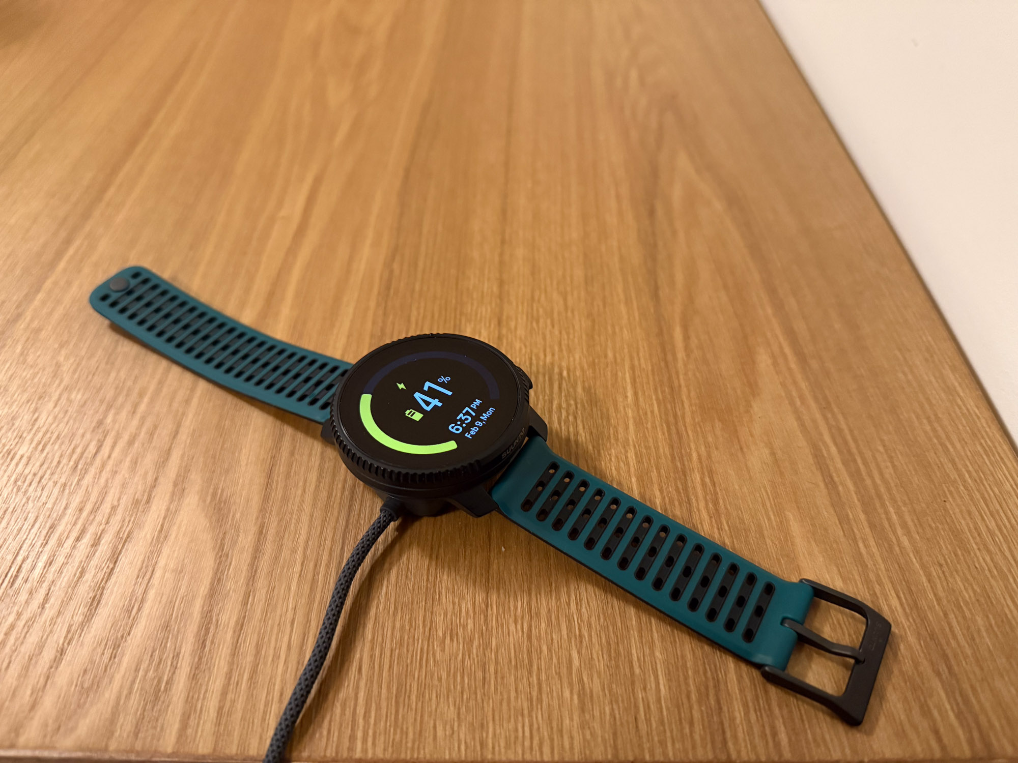 the sunnto vertical 2 charging on a wooden desk