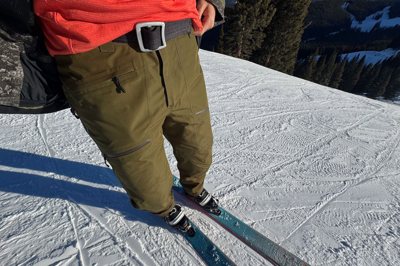 Powderverse pants showing the waistband and upper leg fit while standing on skis