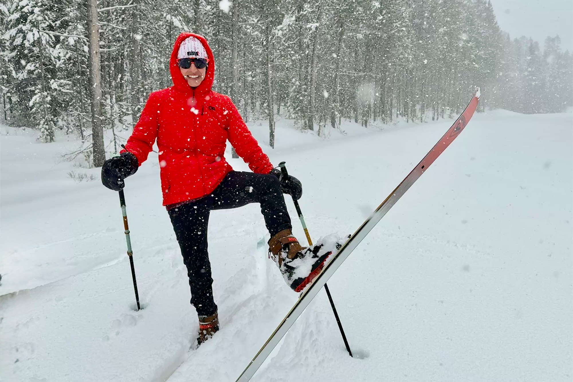 A skier stands in falling snow wearing the Rossignol XP 105 Positrack skis