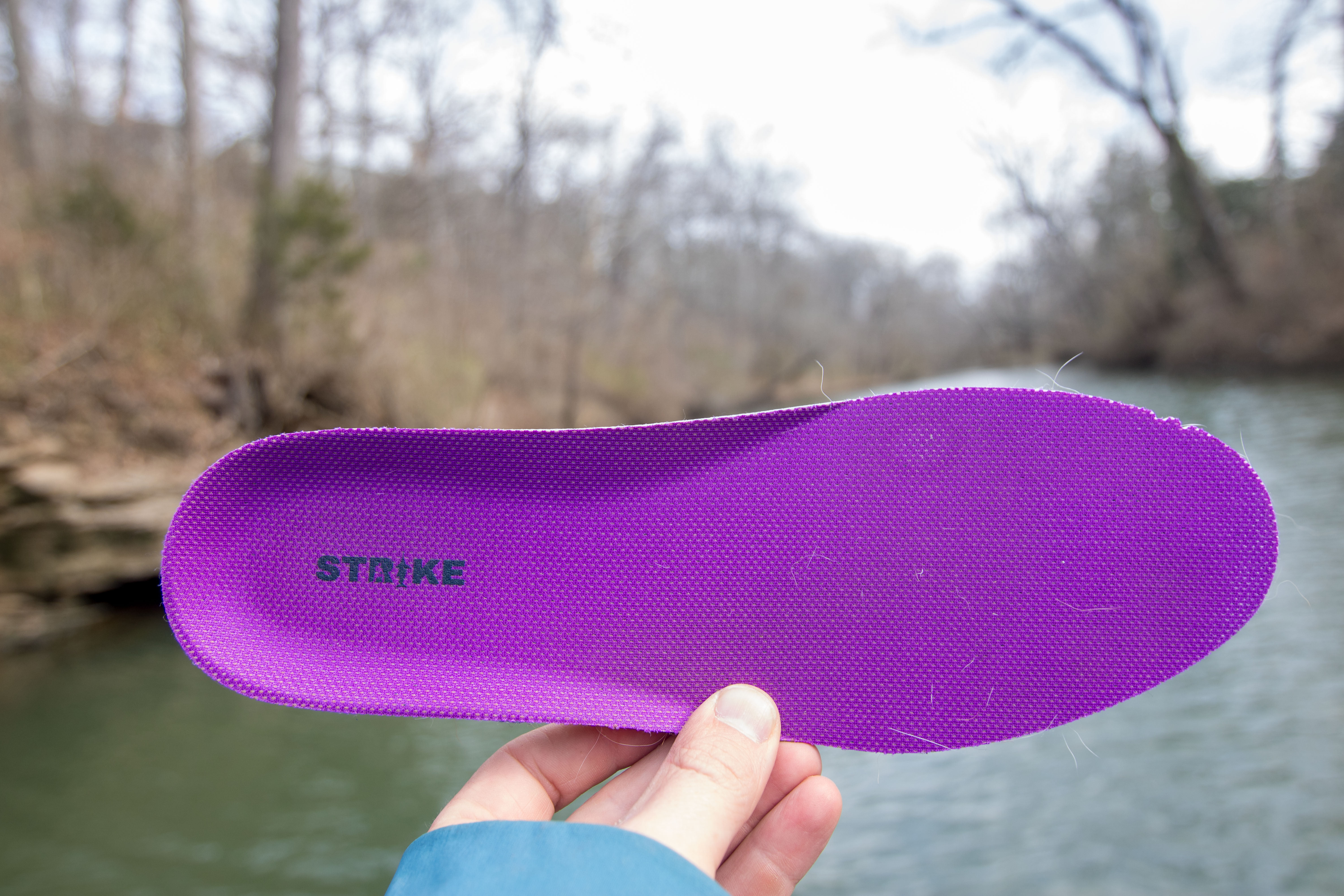 The insole of the Strike Bigeye Boot in front of a lake.