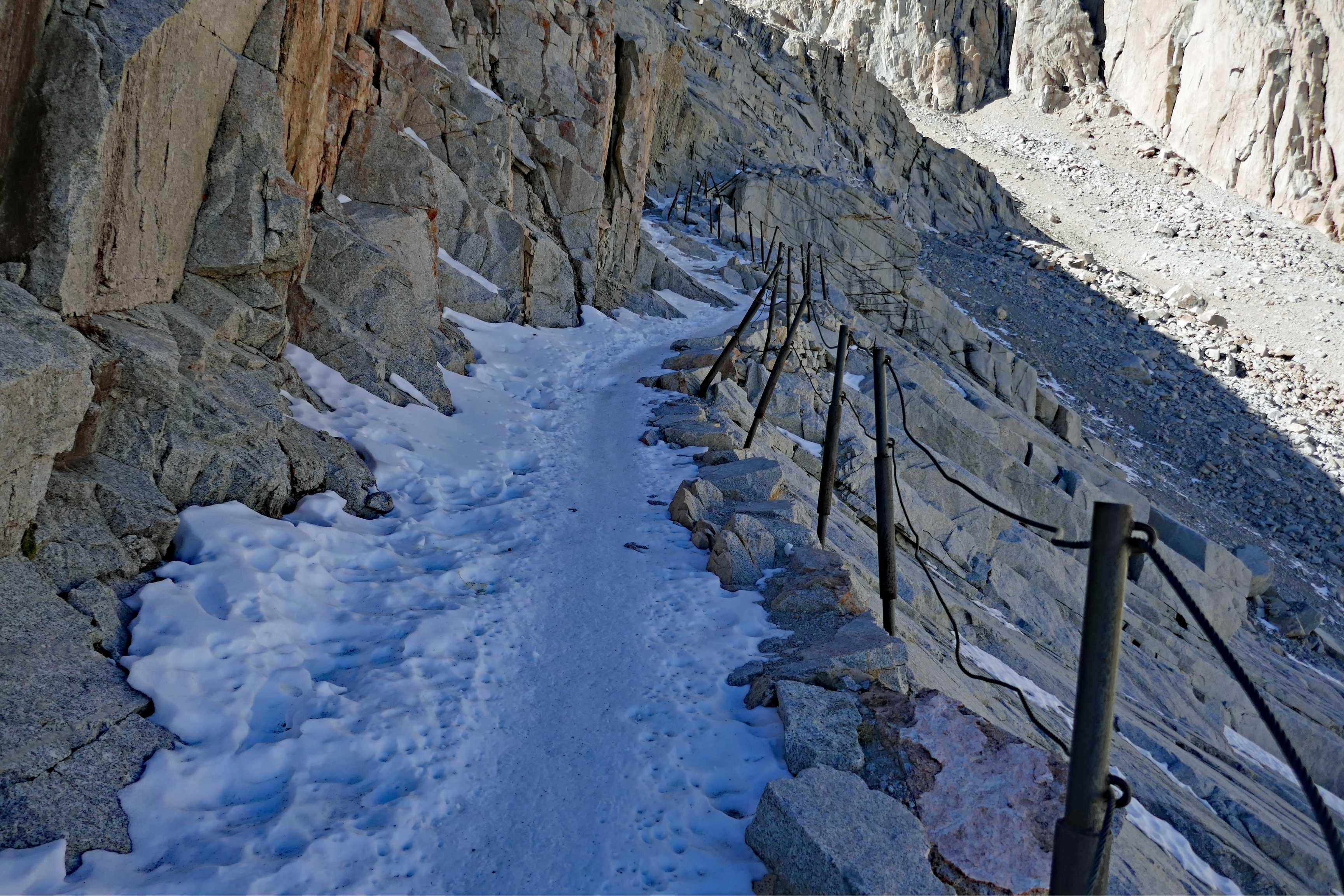 trail covered in snow with cables alongside