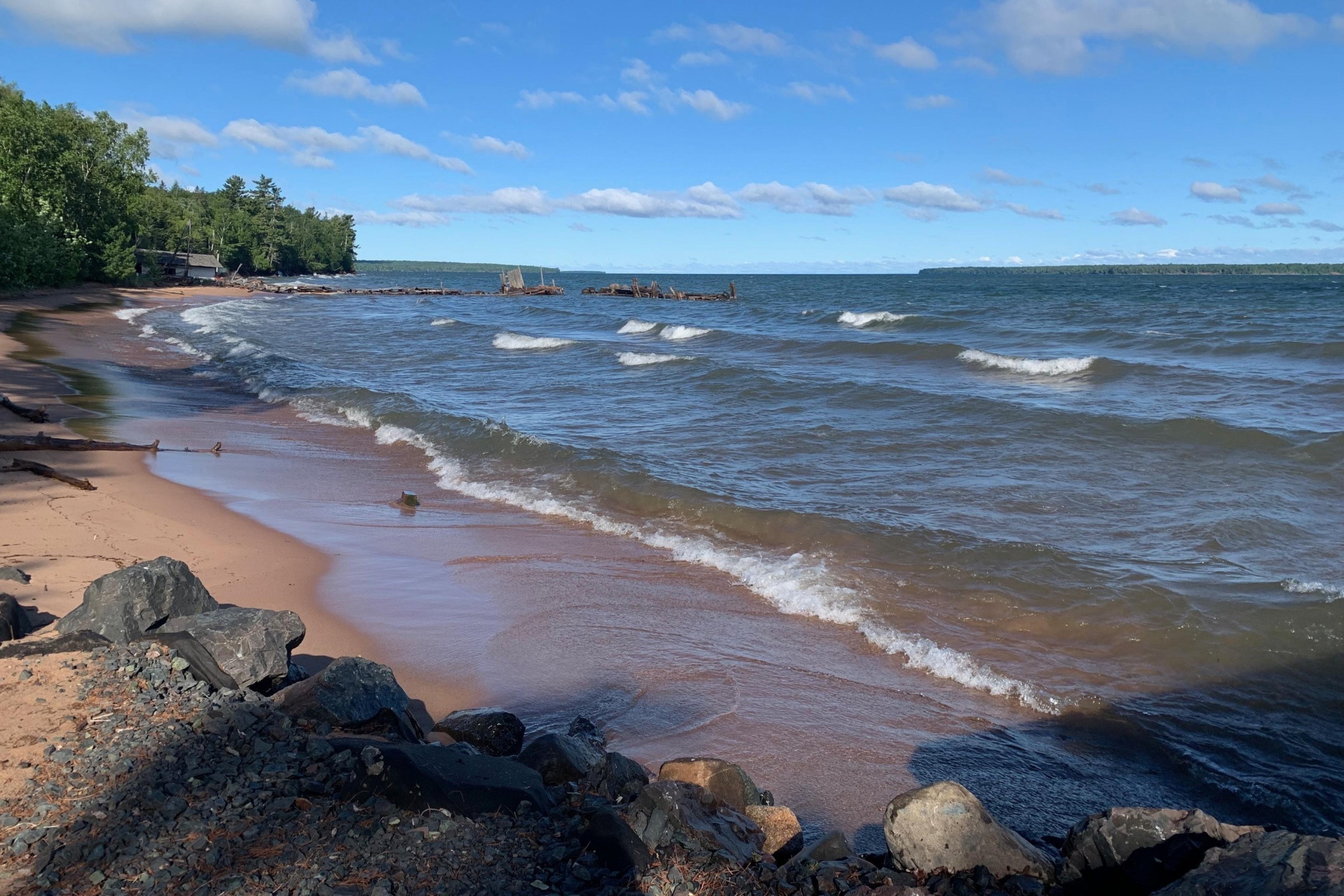 sandy beach with waves and blue sky