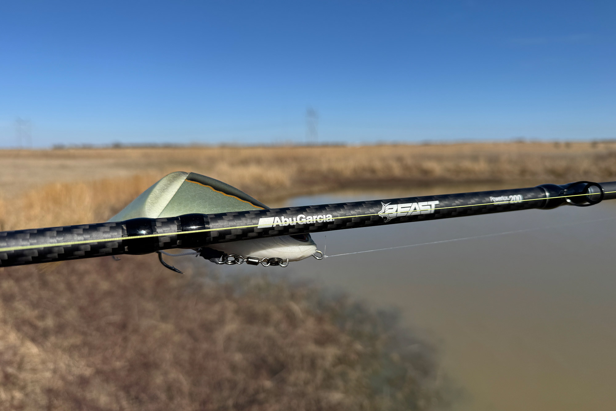 The Abu Garcia Beast combo rod shows carbon fiber blank and branding near a swimbait lure