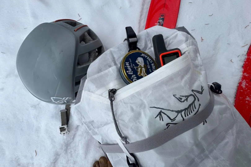 The Alpha SL pack front pocket holding small essentials during a winter outing