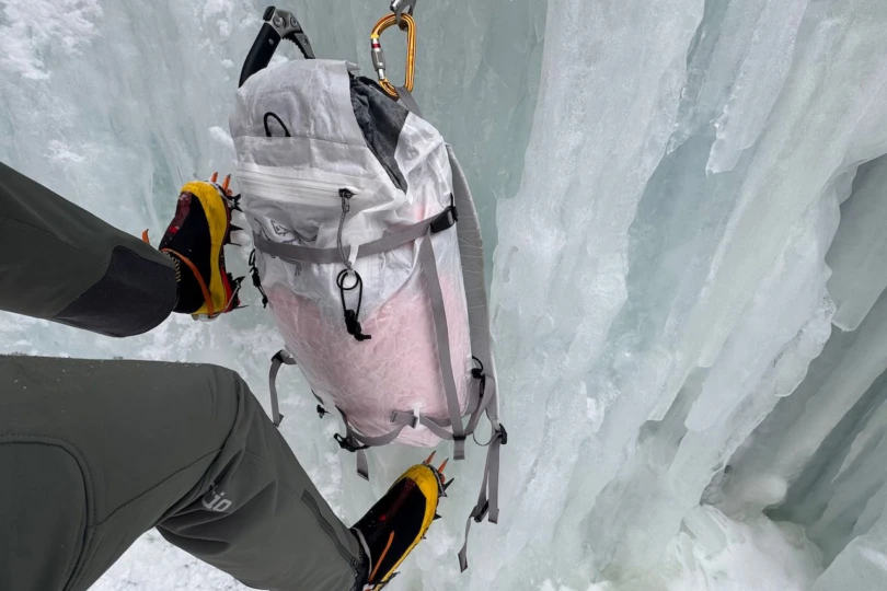 An Arc’teryx climbing backpack worn while moving on an icy route
