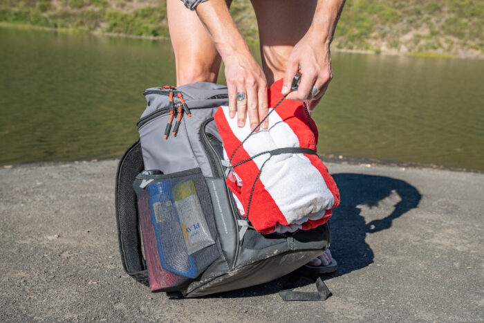 person putting beach towel on pack
