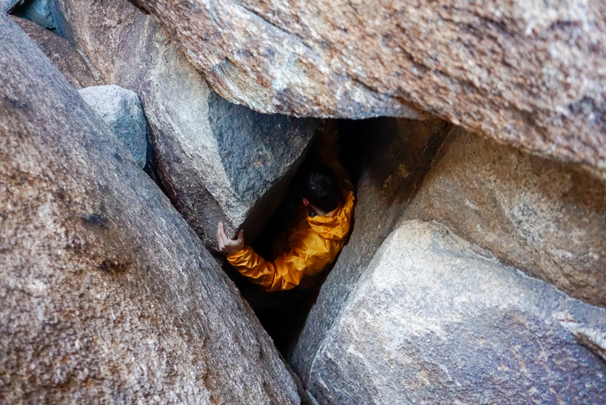 Outdoor Research Helium Rain Jacket Stress Test A Climber Descends Into a Hole in the Rock Wearing the Outdoor Research Helium Rain Jacket