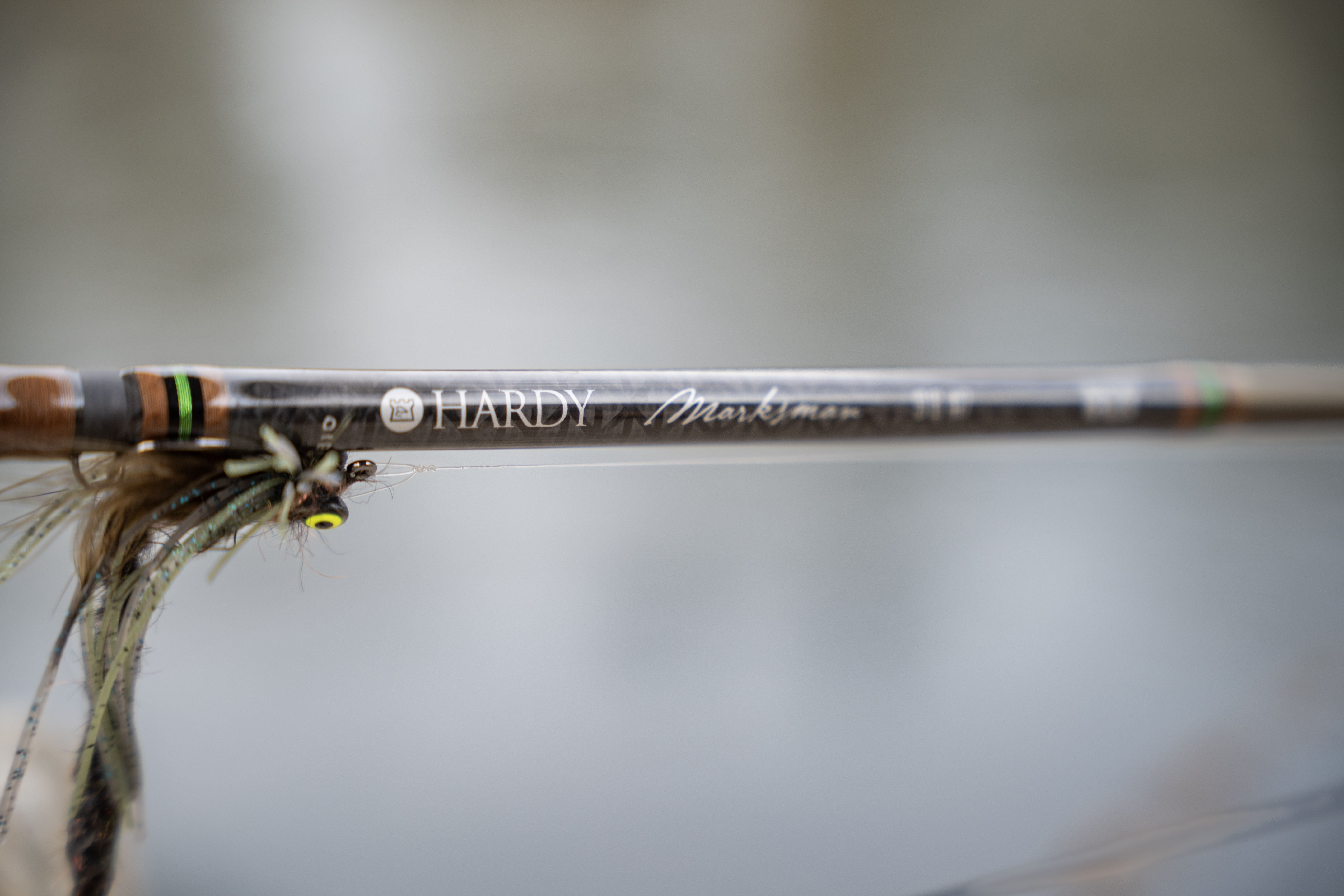 A bass fly next to the label on the Hardy Marksman fly rod.