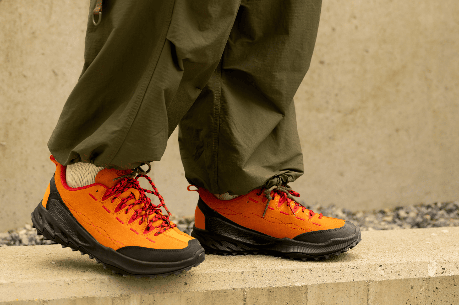 A person wearing a pair of KEEN Jasper Zionic orange shoes