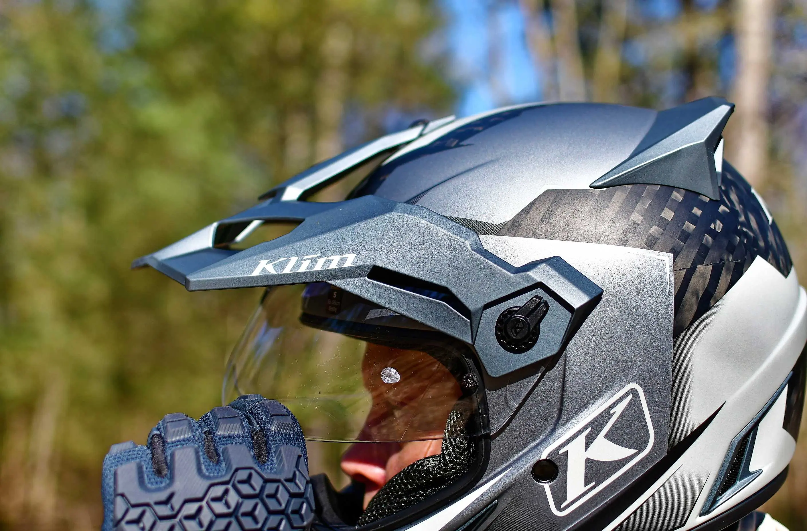 motorcyclist pulling up clear visor on helmet 