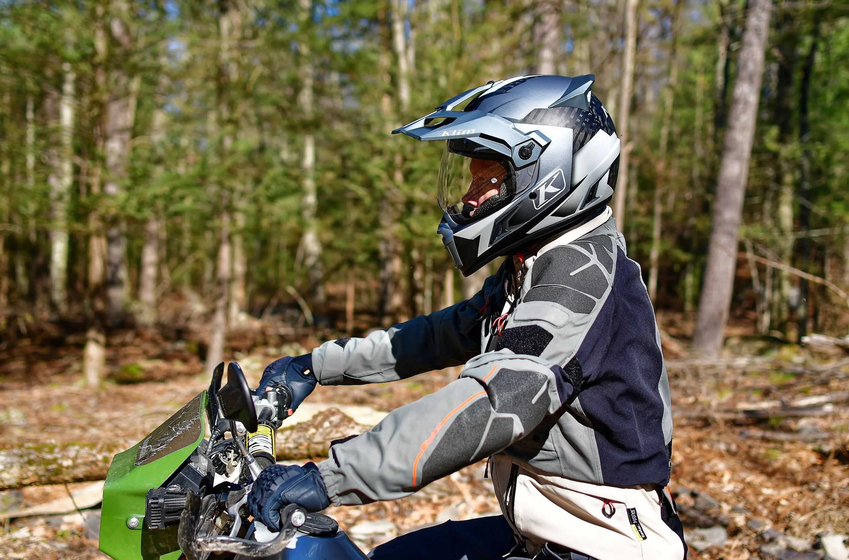 man sitting on motorcycle in wooded area