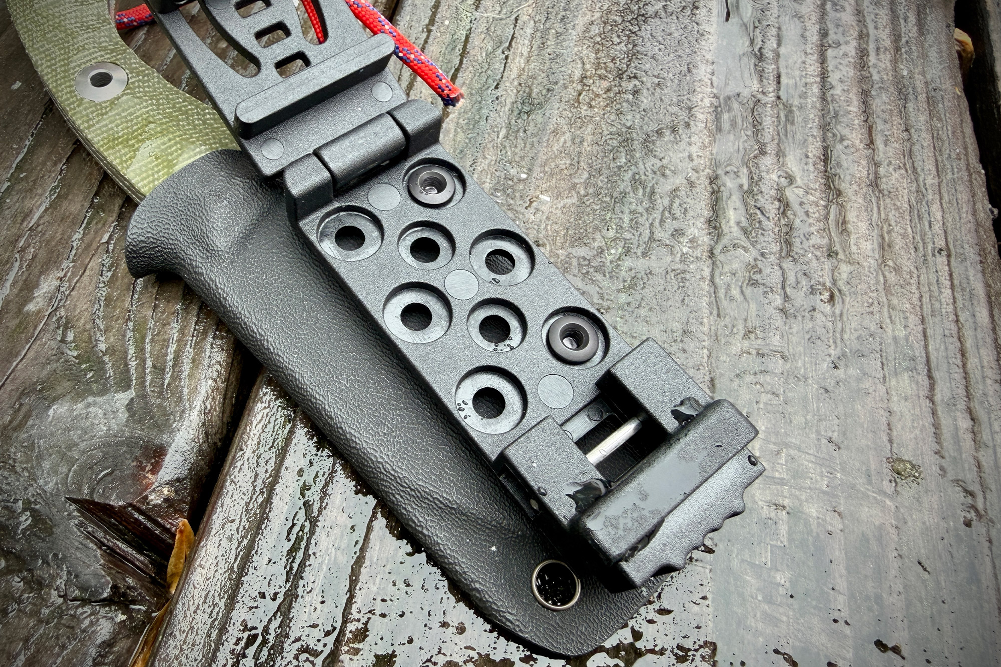 The Kizer Rook sheath with the belt clip open, showing mounting holes and hinge