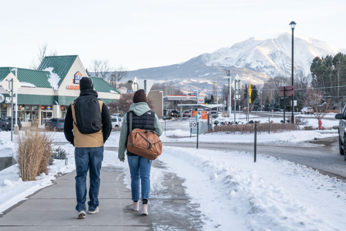 two gearjunkie laptop bag testers walking in the snow in colorado wearing packs