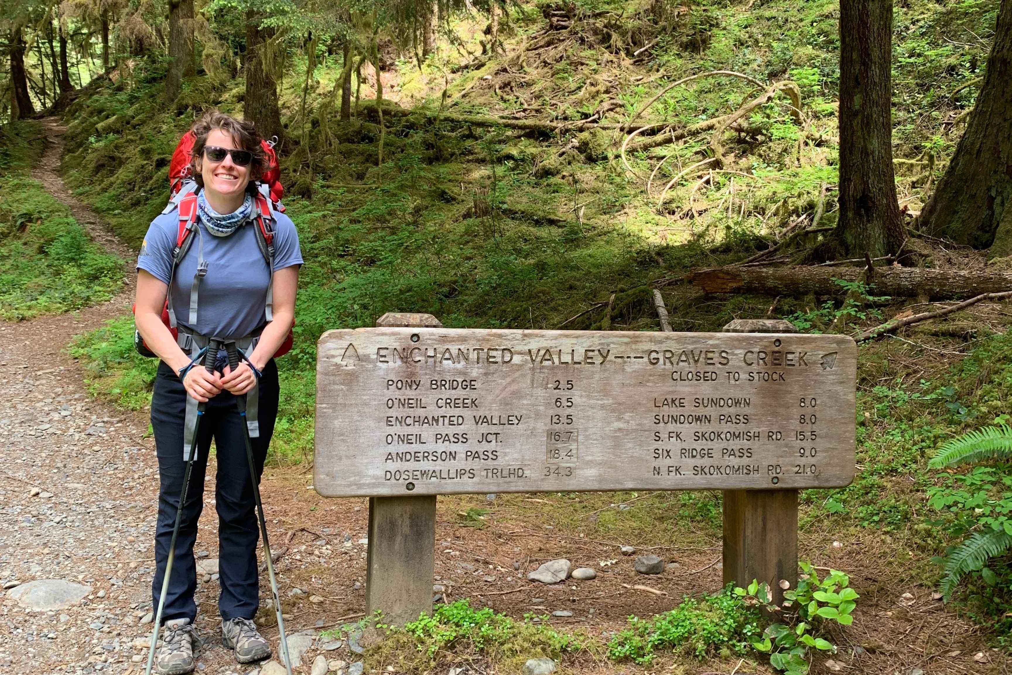 backpacker stands in front of sign