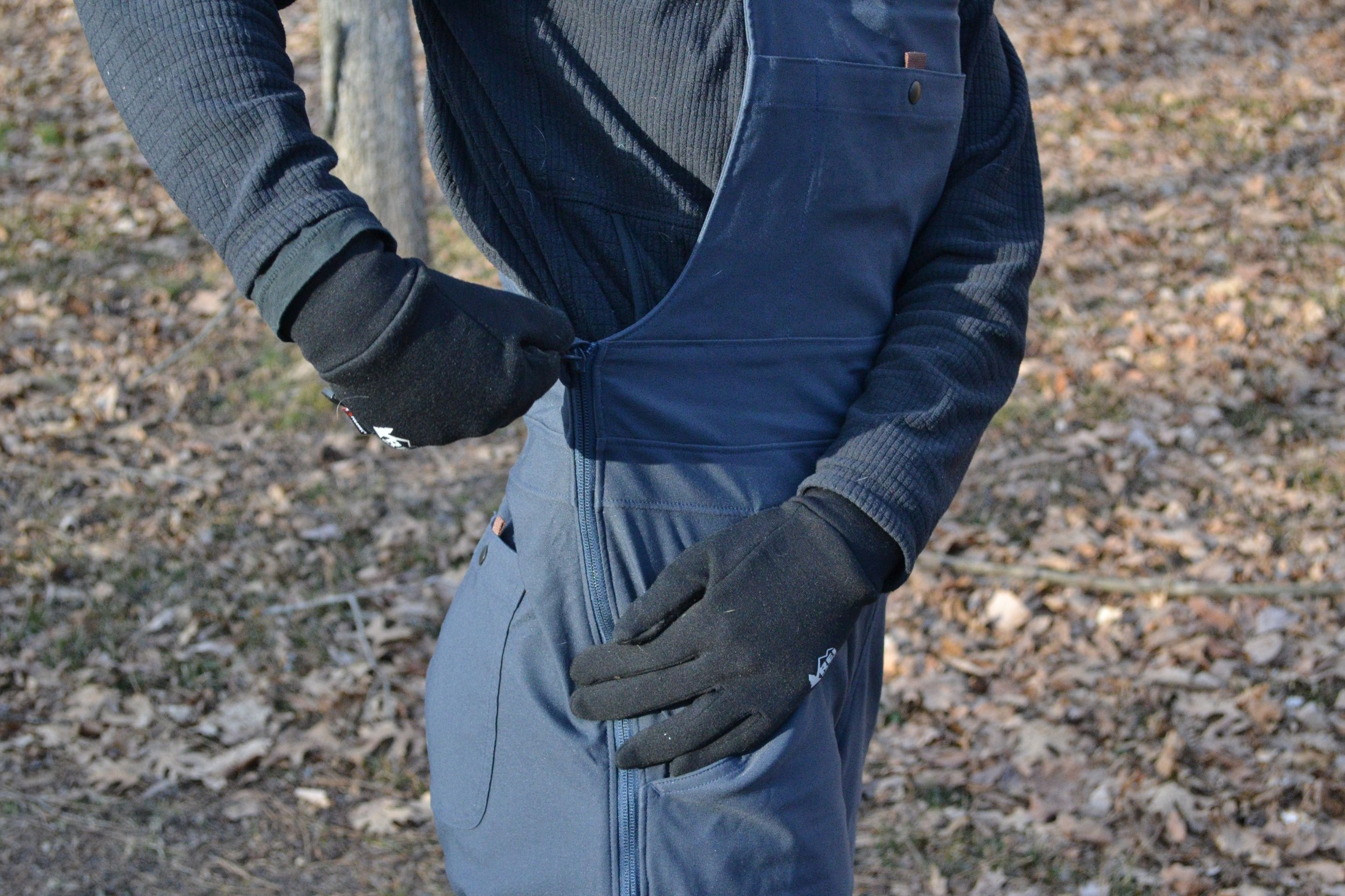 person zipping up side zipper on overalls