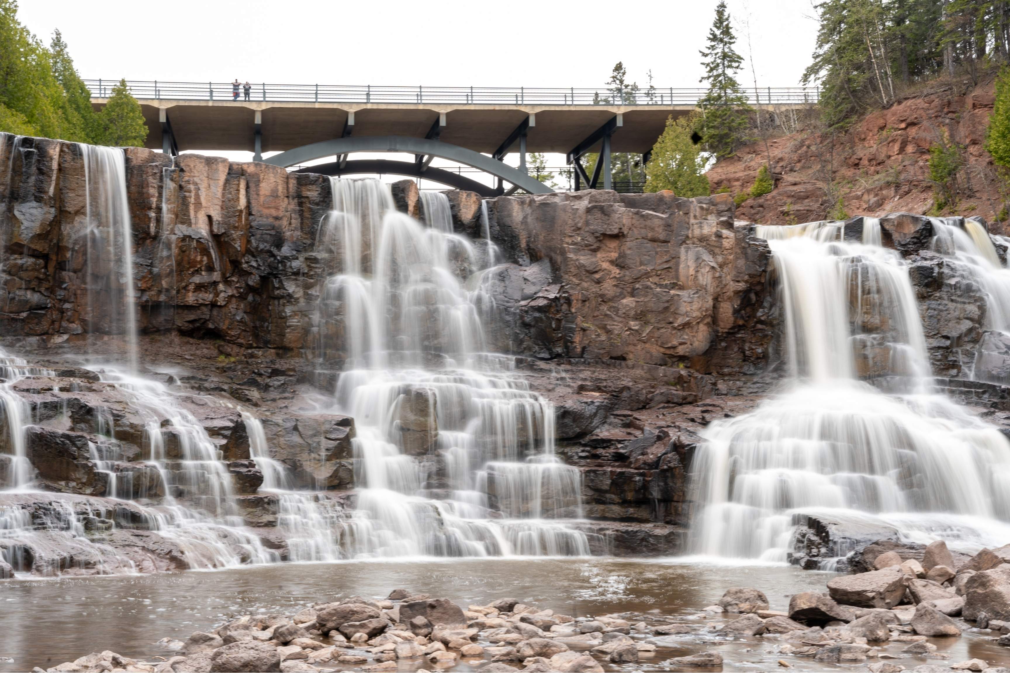 waterfalls with bridge over them