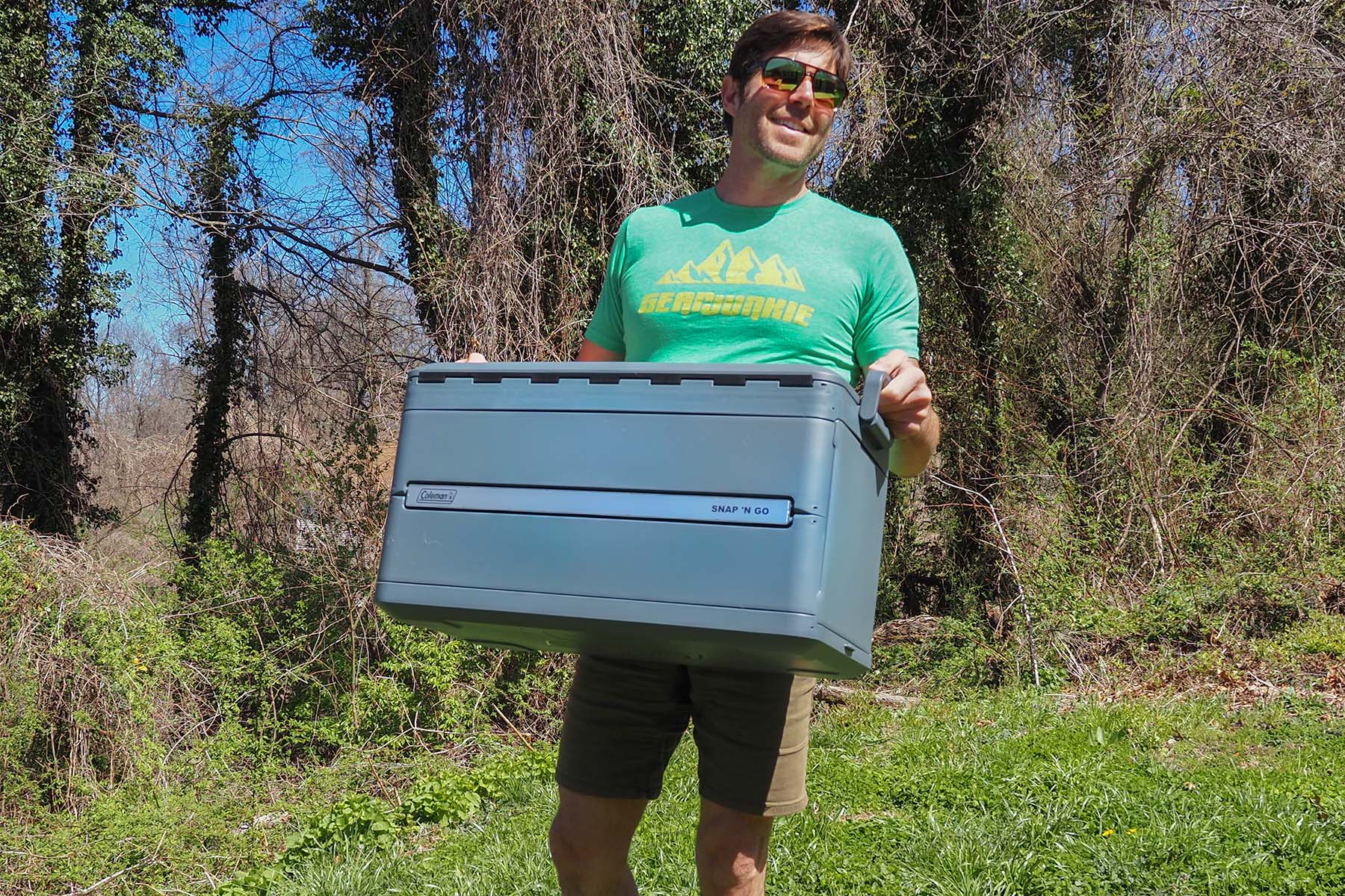 handsome man carrying a cooler outside