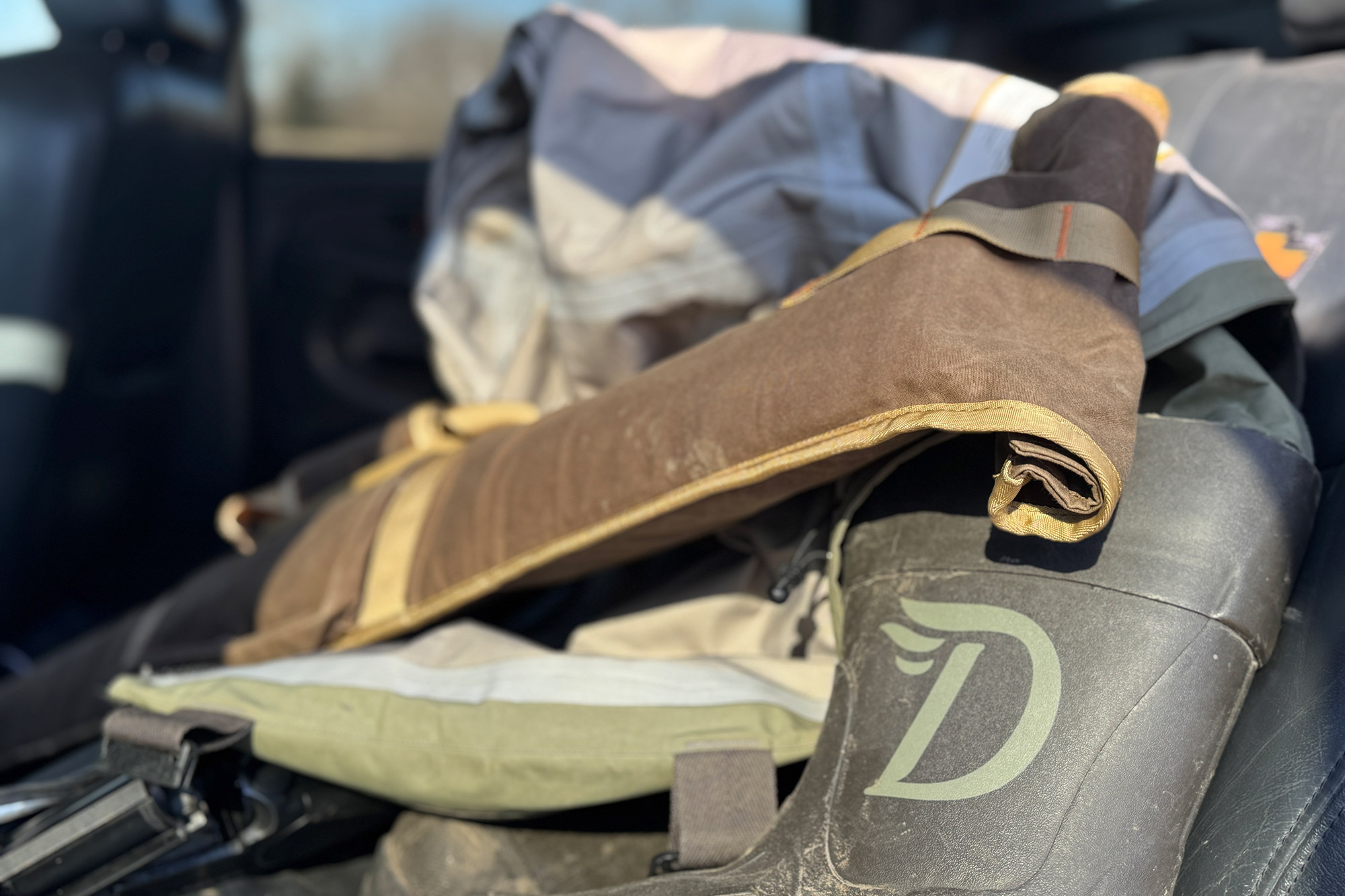 Duck Camp Canvas Gun Sleeve resting on a truck seat with other gear
