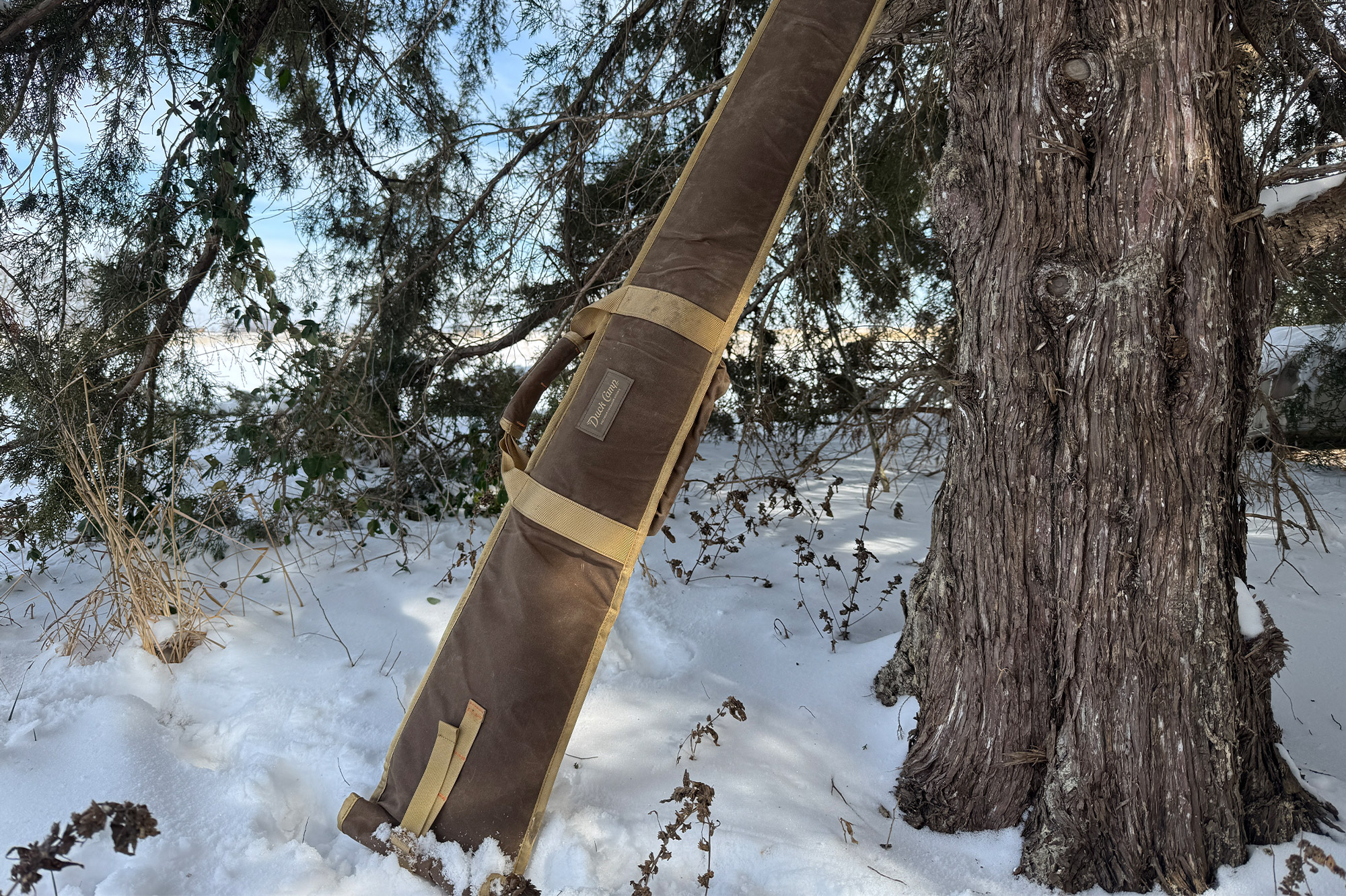 Duck Camp gun sleeve leaning against a tree in snow