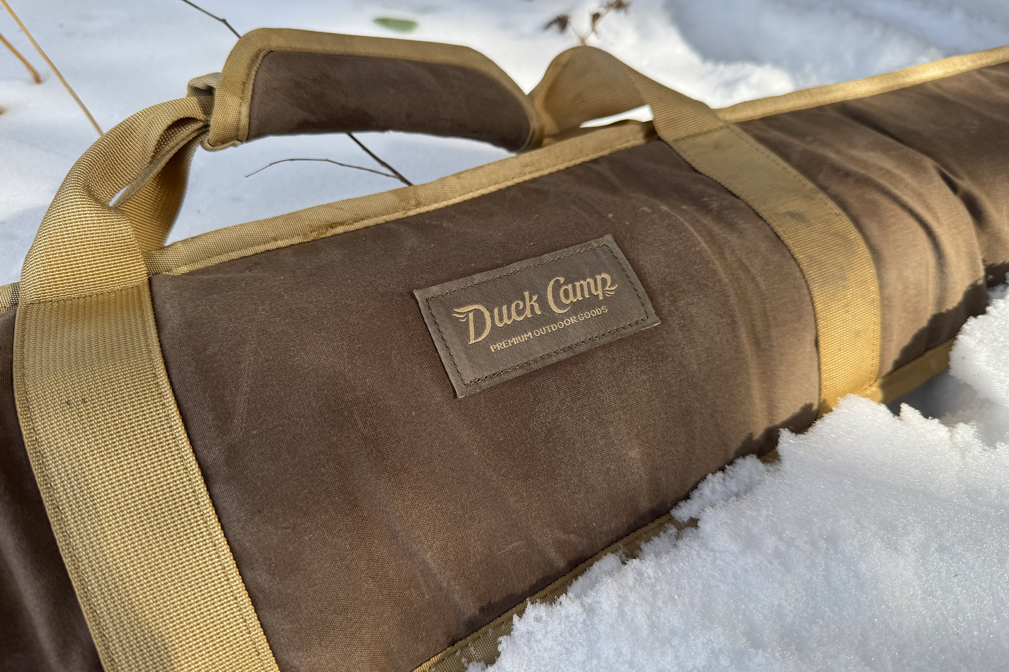 Duck Camp sleeve partially covered in snow showing logo