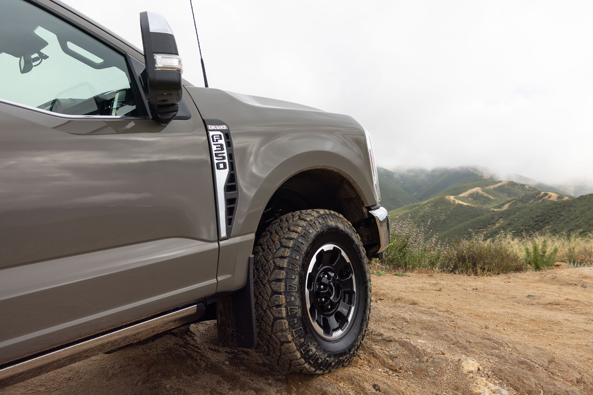 Front wheel and fender of the 2026 Ford F 350 Tremor on a dirt trail