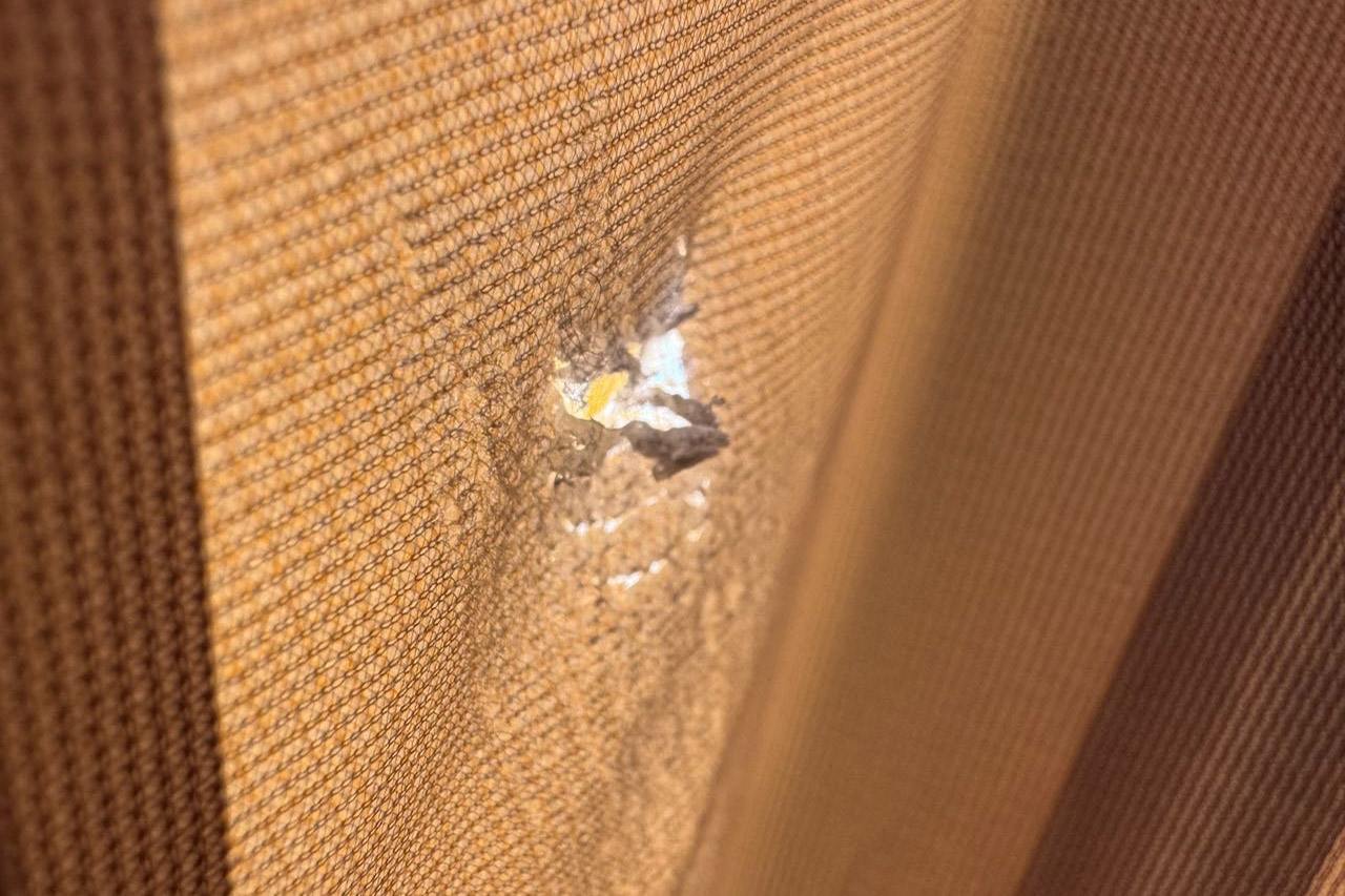 Close up of small tear in tent fabric showing inner layer