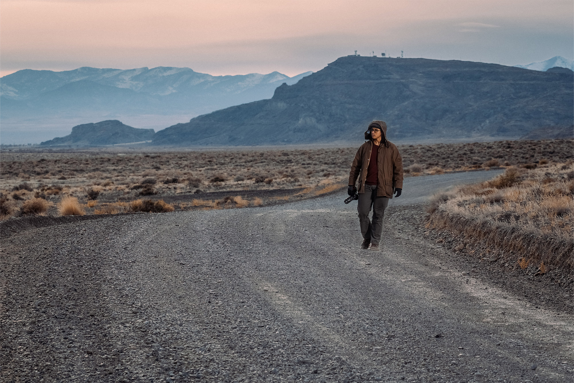 A person walking on an open landscape wearing the Barbour Beaufort Wax Jacket
