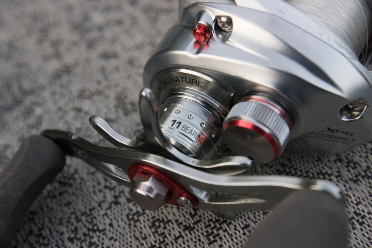 The reel handle and specs displayed on the Johnny Morris Platinum Signature baitcaser