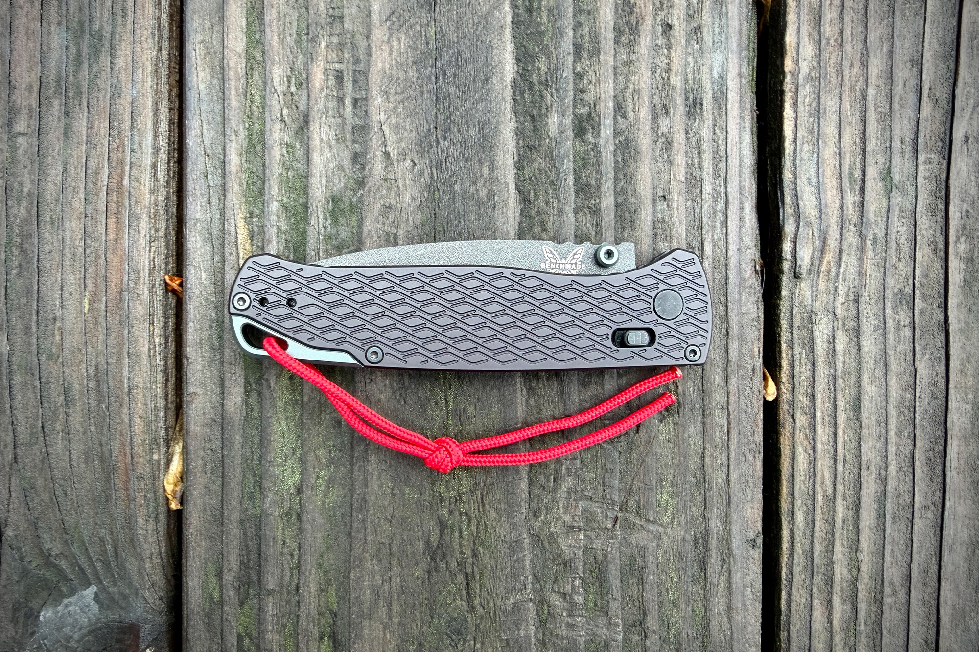 Bugout Vapyr closed on wooden background with red paracord lanyard