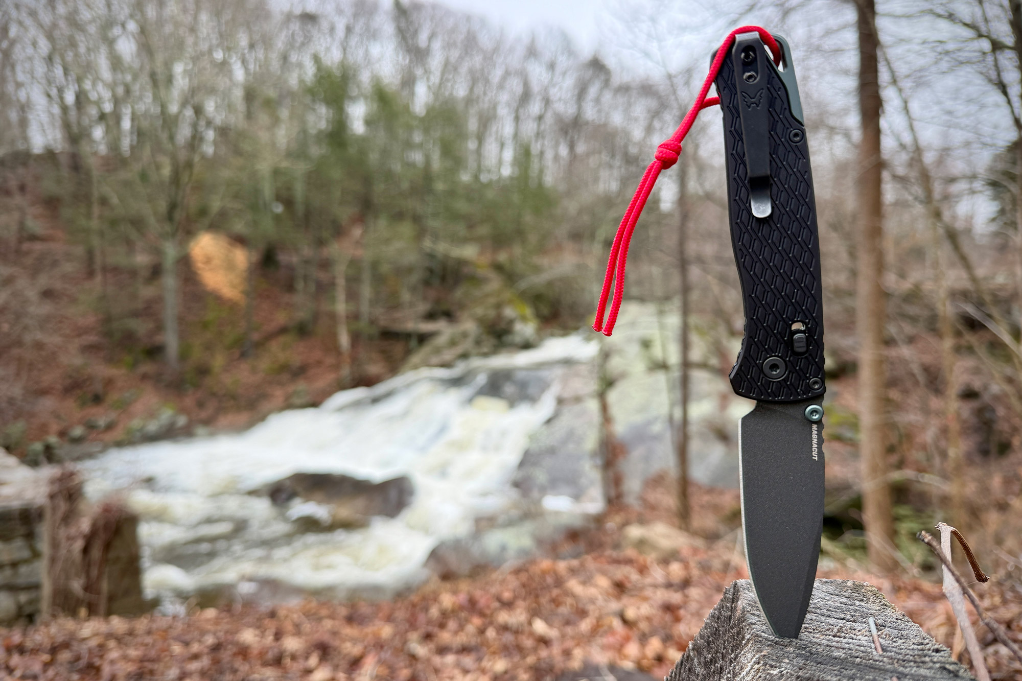 Bugout Vapyr standing tip-down on wood with waterfall in background