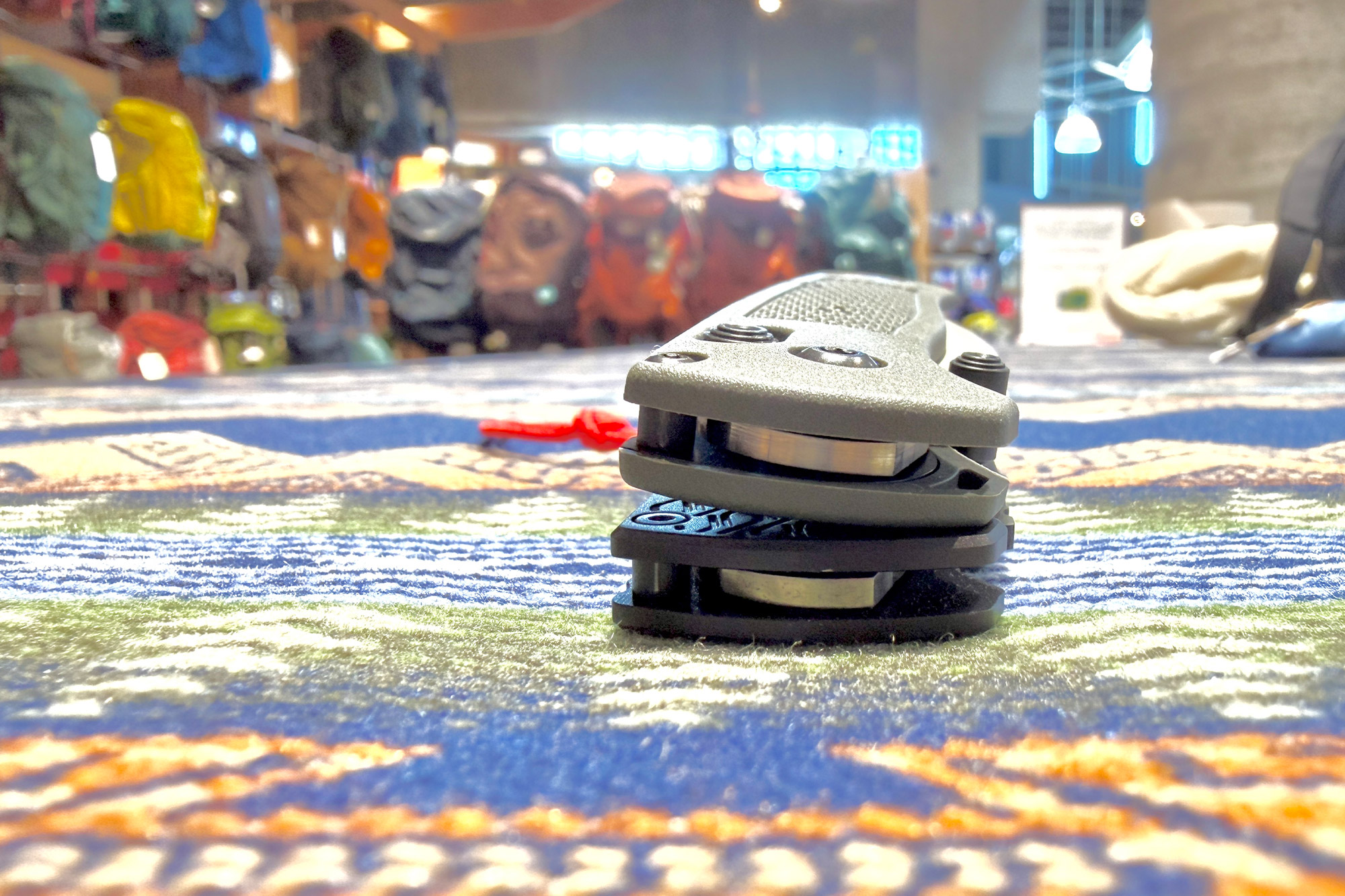 Benchmade Vapyr closed knife stacked with another folder on indoor surface