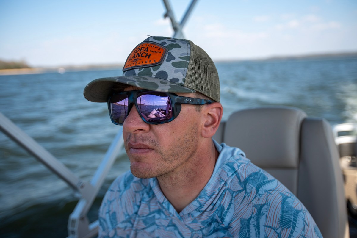 A man driving a boat while wearing the Bajio Cocho sunglasses.