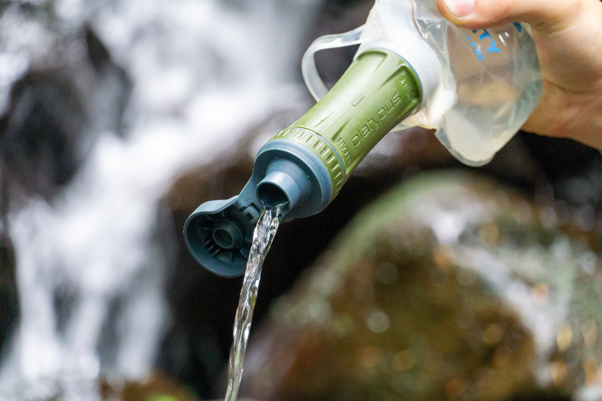 the author using a platypus quickdraw water filter in washington state beside a creek